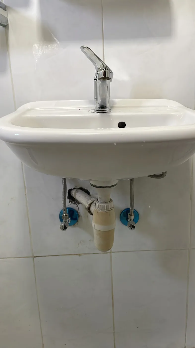 ברז חדש ושני ברזי ניל חדשים עם צינורות גמישים מתחת לכיור רחצה בבת ים לאחר ההחלפה
