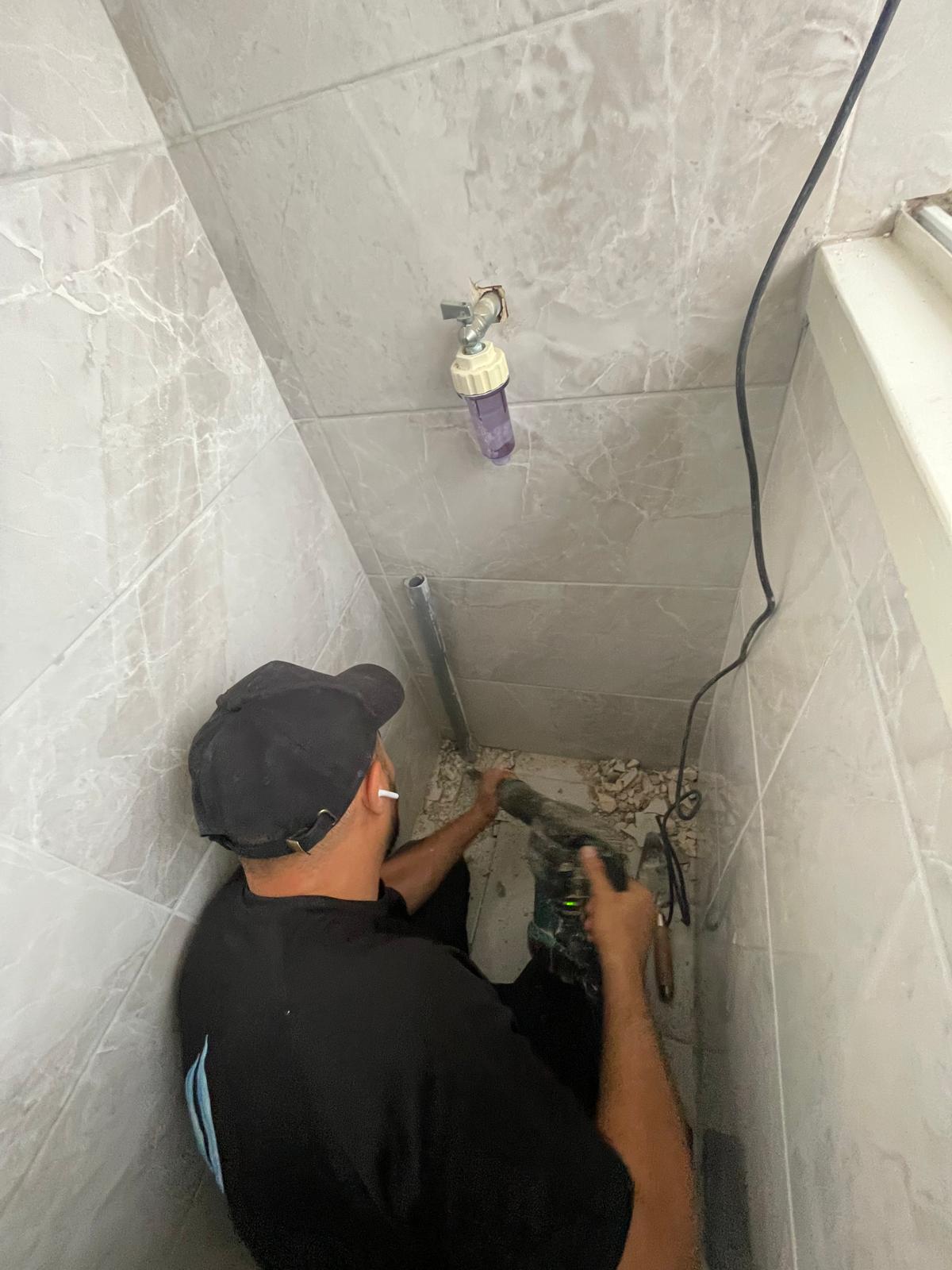 פתיחת אריח באזור מסנן מים ראשי לאיתור נזילה סמויה - יצחק האינסטלטור