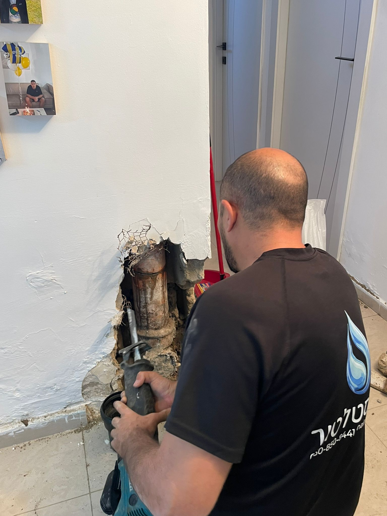 יצחק מהאינסטלטור מתקן צנרת מחולדת בדירה בחולון באמצעות כלי חיתוך
