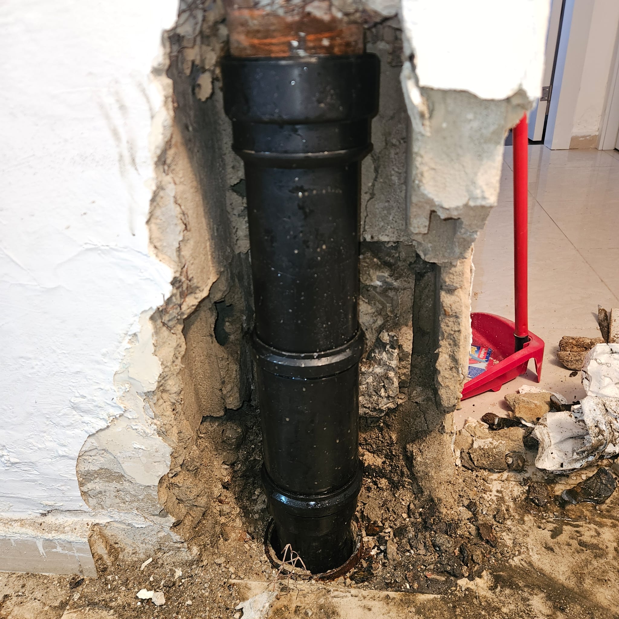 צנרת פלסטיק חדשה מותקנת בקיר אחרי איתור ותיקון נזילה בחולון