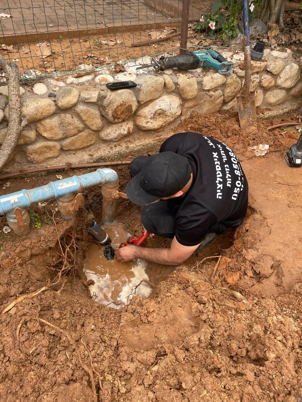 יצחק עקרי מתקן צינור מים פרוץ בשטח