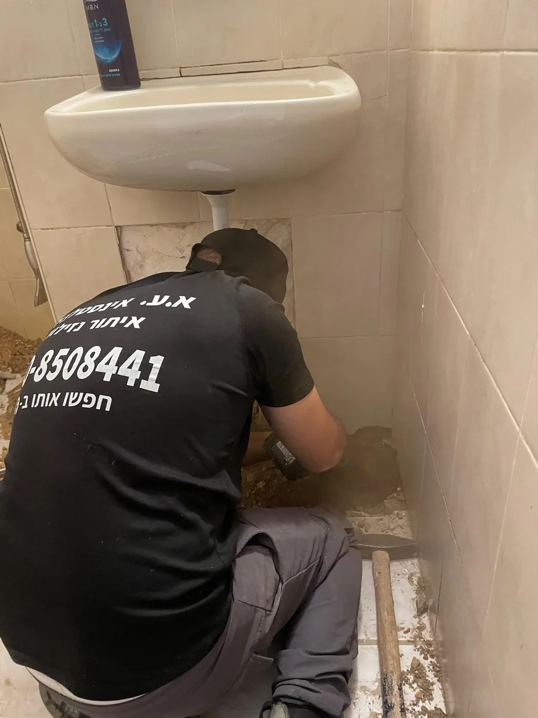 יצחק עקרי בעבודת איתור נזילות מתחת לכיור